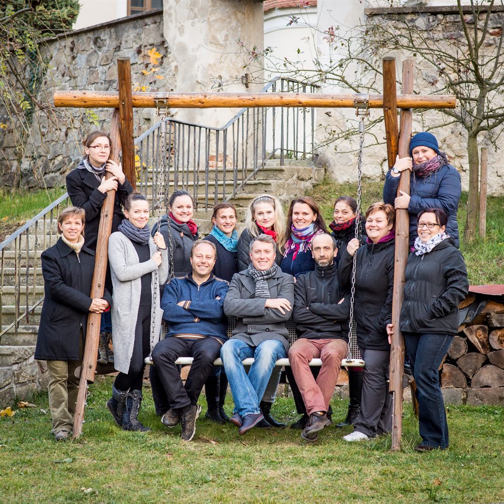Skupinová fotografie členů Labyrintu u dřevěné houpačky na zahradě